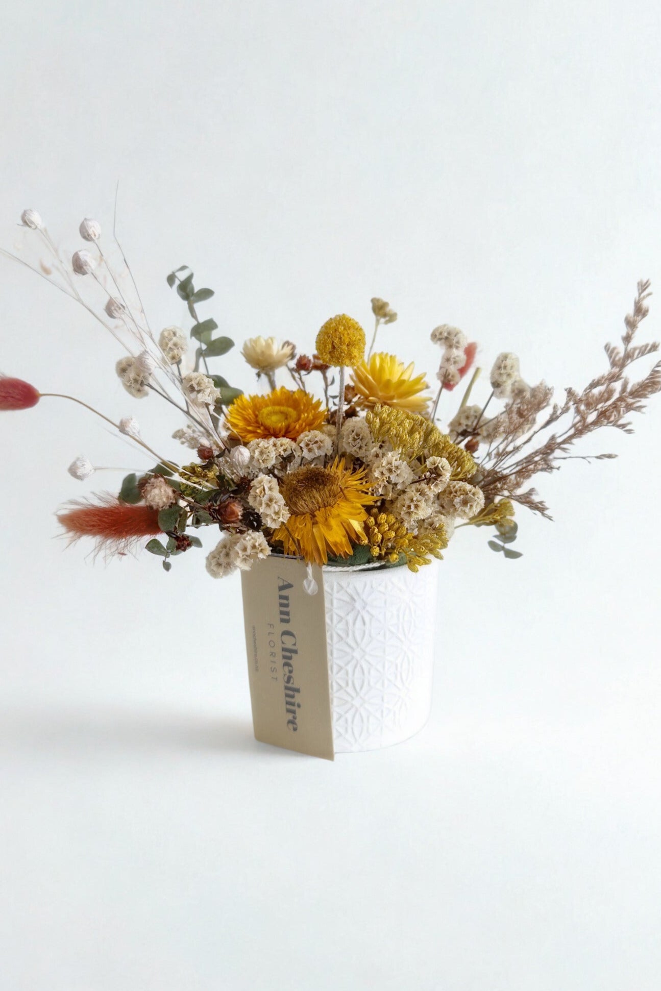 Bouquet of dried flowers with a tag on a white background