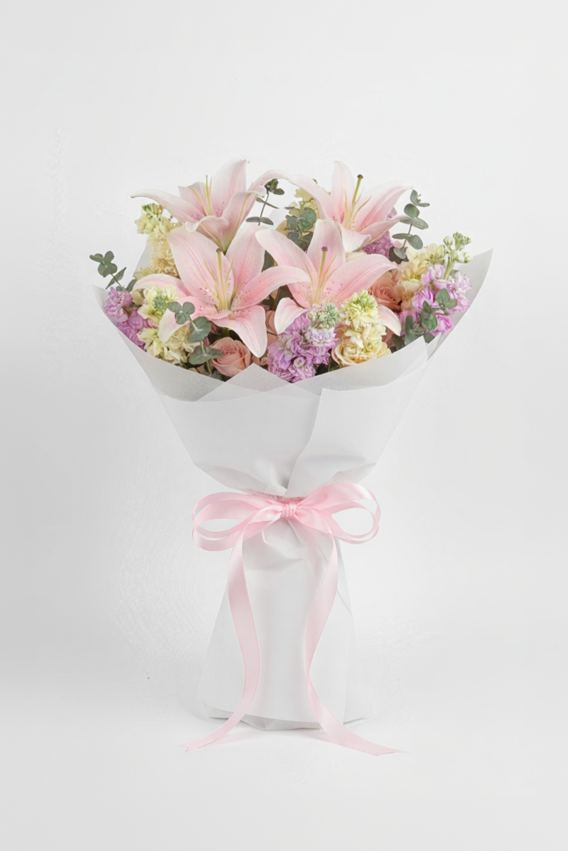 Bouquet of flowers wrapped in white paper with a pink ribbon on a light background
