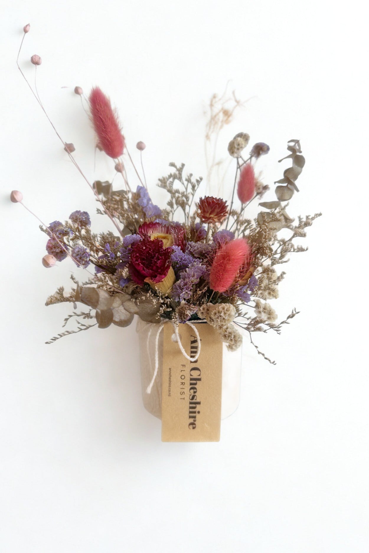 Dried flower arrangement with a tag on a white background