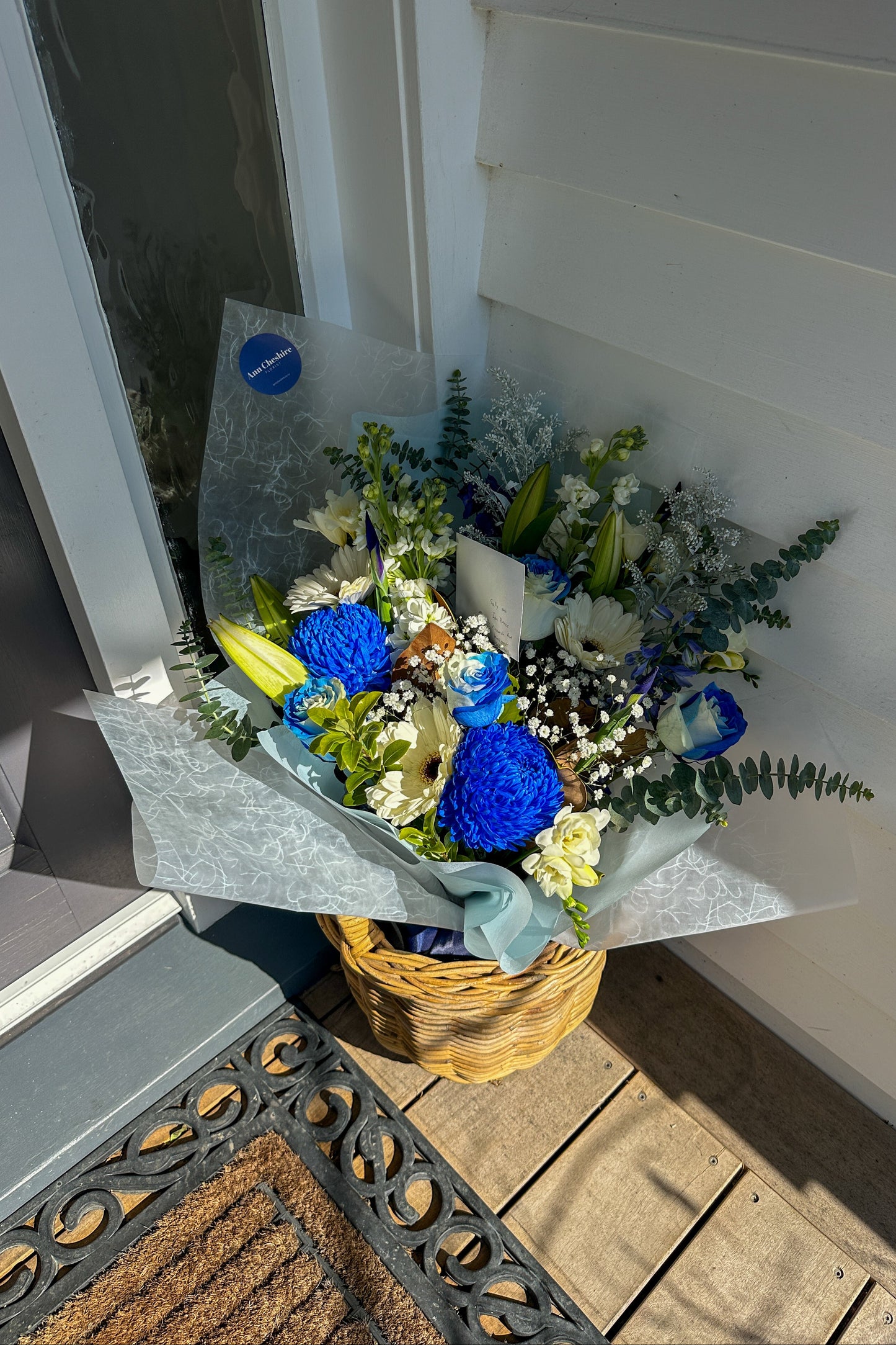 Bouquet of flowers in a basket on a doorstep
