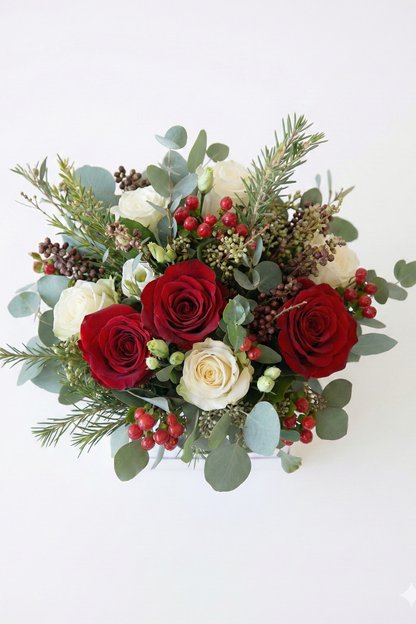 Bouquet of red and white roses with greenery on a white background