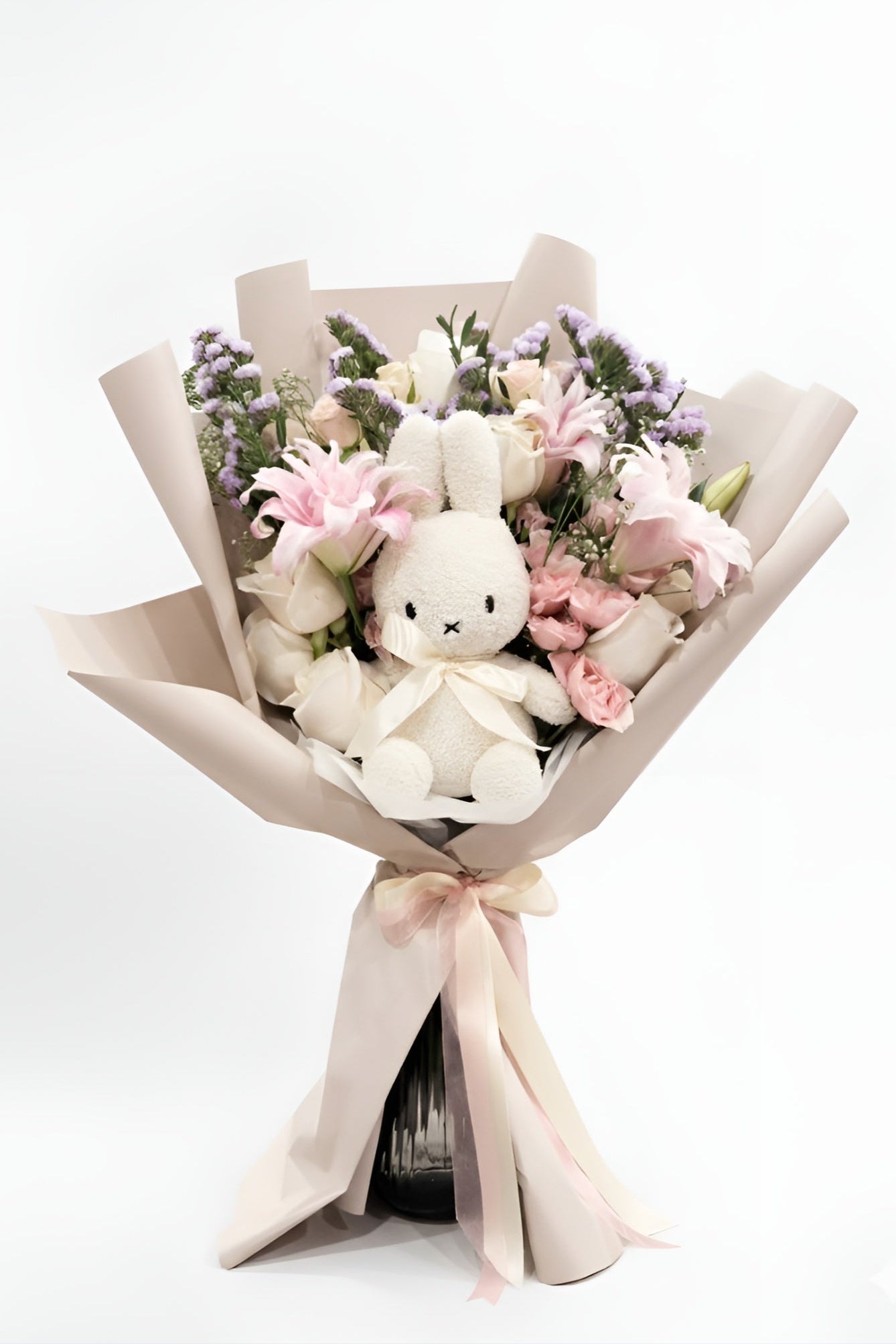 Bouquet with a plush toy rabbit and flowers on a white background