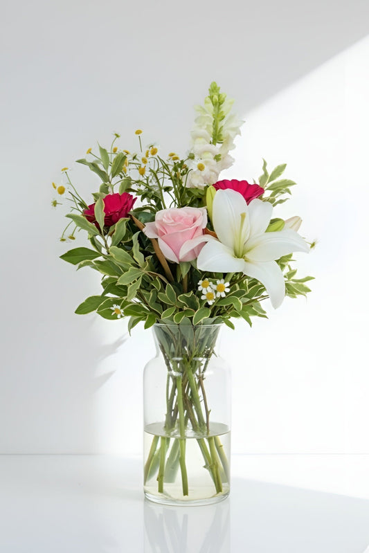 Bouquet of flowers in a clear vase on a white background