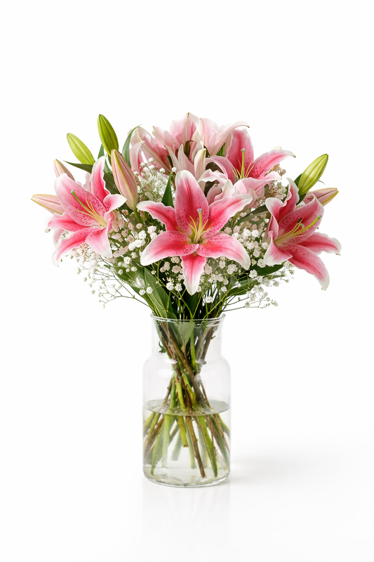 Bouquet of pink lilies in a clear vase on a white background