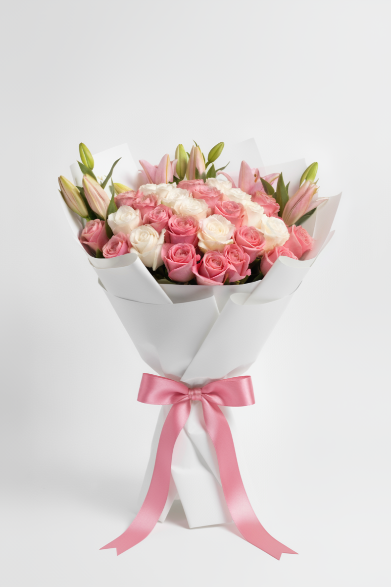 Bouquet of pink and white flowers wrapped in white paper with a pink ribbon on a light gray background