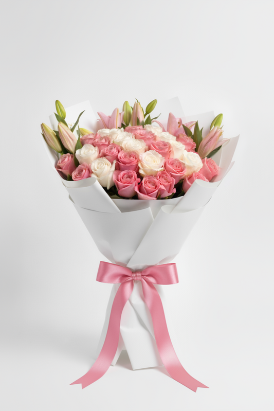 Bouquet of pink and white flowers wrapped in white paper with a pink ribbon on a light gray background