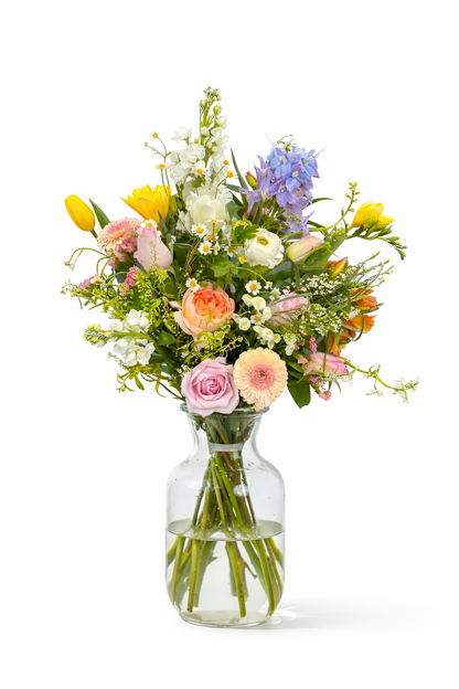 Bouquet of colorful flowers in a clear vase on a white background