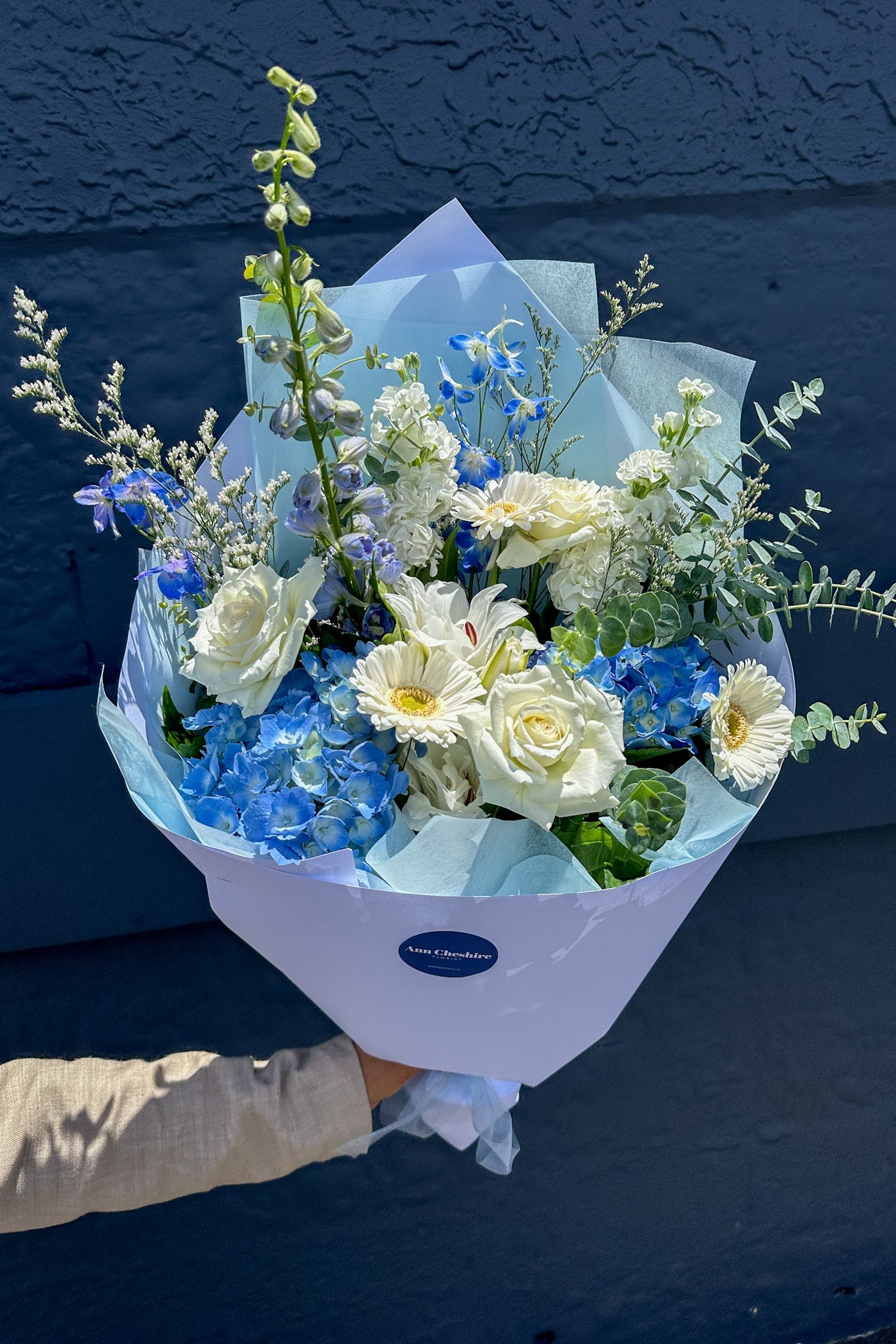 Bouquet of flowers with a visible brand label against a dark blue background