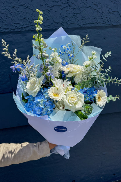 Bouquet of flowers with a visible brand label against a dark blue background