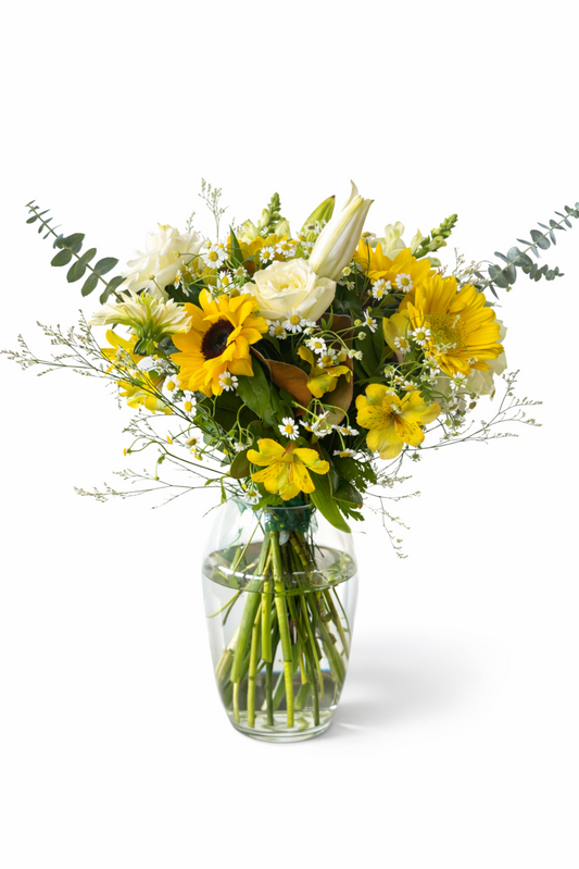 Bouquet of yellow flowers in a clear vase on a white background